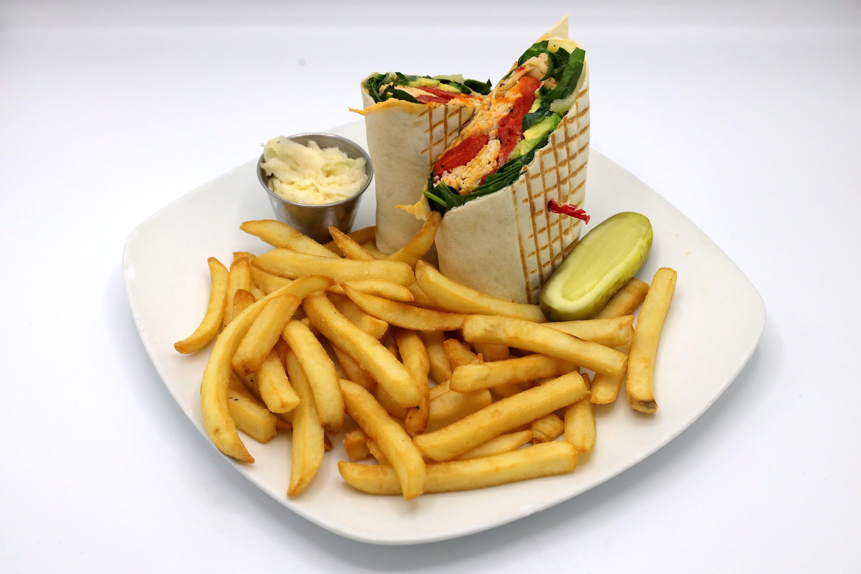 Overstuffed wrap with spinach and roasted peppers, served with fries